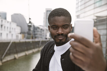 Junger Mann macht ein Selfie im Freien - STKF001406