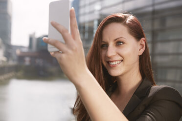 Junge Frau macht ein Selfie im Freien - STKF001410