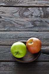 Two apples and wooden spoon on dark wood - CSF026148