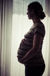 Pregnant woman against bright window - KRPF001597