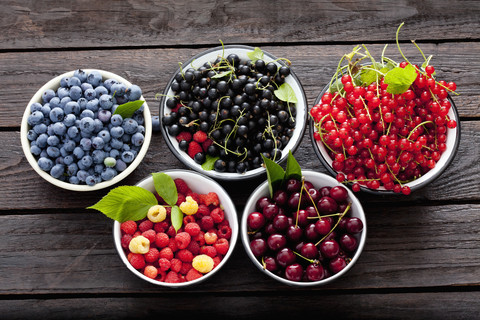 Schalen mit Sauerkirschen, Himbeeren, roten und schwarzen Johannisbeeren und Heidelbeeren, lizenzfreies Stockfoto