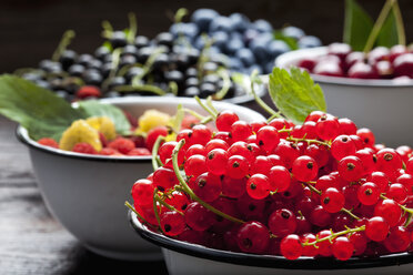 Bowl of red currants and bowls of other berries in the background - CSF026130