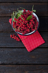 Schale mit roten Johannisbeeren auf Stoff und dunklem Holz - CSF026121