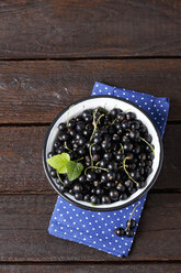 Bowl of black currants on cloth and dark wood - CSF026120