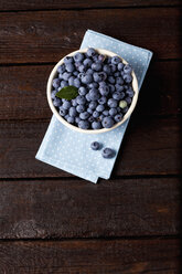 Bowl of blueberries on cloth and dark wood - CSF026119