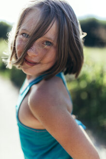 Porträt eines lächelnden Mädchens mit braunen Haaren und Sommersprossen - MGOF000434