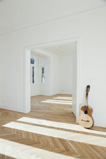 Gitarre an die Wand gelehnt, leerer Raum - CHAF001052