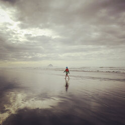 Neuseeland, Bay of Plenty, Ohope Beach, Frau geht am Strand entlang, Mount Waleback im Hintergrund - GWF004372