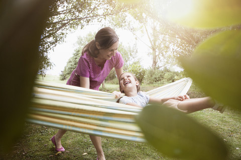 Relaxed mother and daughter in hammock stock photo