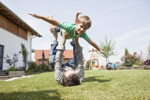 Verspielter Vater mit Sohn im Garten - RBF003480