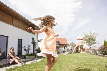 Playful girl with family in garden - RBF003485