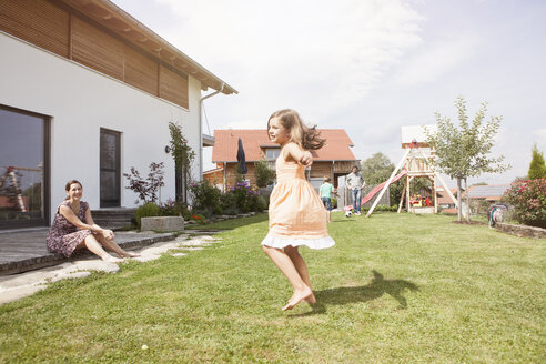 Verspieltes Mädchen mit Familie im Garten - RBF003486