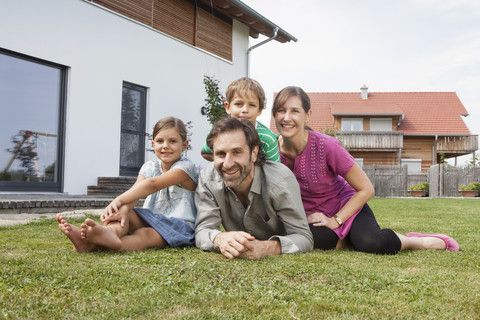 Portrait of smiling family of four in garden stock photo