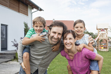 Porträt einer glücklichen vierköpfigen Familie im Garten - RBF003494