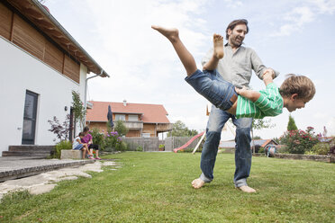 Playful father with son in garden - RBF003495