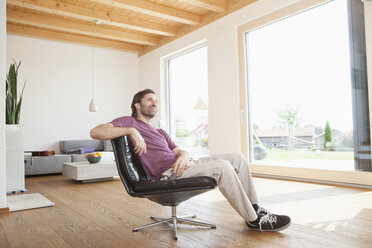Mature man sitting relaxed in his living room - RBF003340