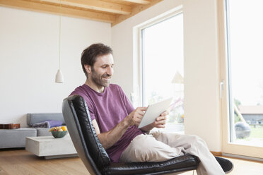 Mature woman using digital tablet at home - RBF003265