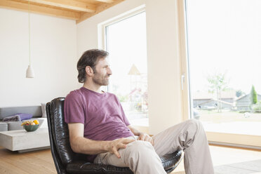 Mature man sitting relaxed in his living room - RBF003266