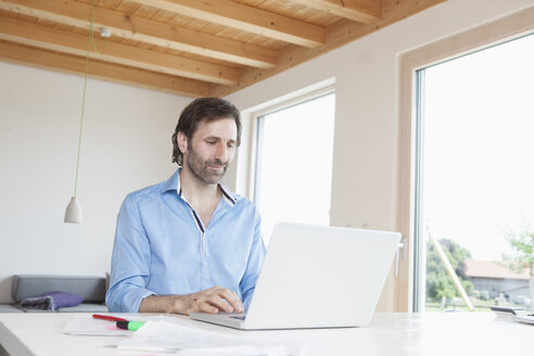 Reifer Mann arbeitet von zu Hause aus, mit Laptop - RBF003271