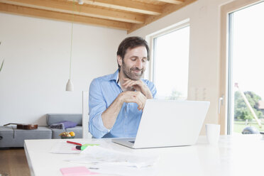 Reifer Mann arbeitet von zu Hause aus, mit Laptop - RBF003272