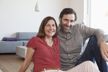 Mature couple sitting on floor of living room - RBF003294