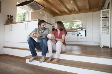 Mature couple sitting on floor, talking about future - RBF003298