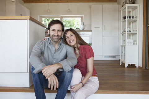 Mature couple sitting on floor, front view stock photo