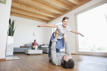 Father and daughter playing at home, pretending to fly - RBF003316