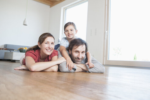 Glückliche Familie auf dem Boden liegend, lächelnd - RBF003317