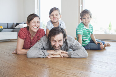 Glückliche Familie auf dem Boden liegend, lächelnd - RBF003322