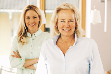 Portrait of smiling mature woman with adult daughter in background - CHAF001092