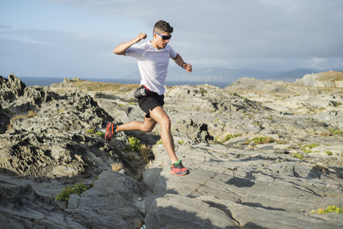 Spanien, Valdovino, junger Mann beim Trailrunning in einer felsigen Landschaft - RAEF000306