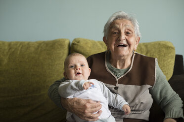 Portrait of great-grandmother sitting on a couch with her great-grandson - RAEF000310