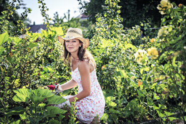 Portrait of smiling woman working in the garden - VTF000440