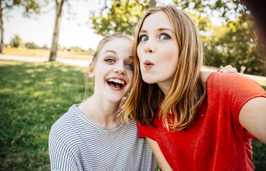Two playful teenage girls taking a selfie - AIF000053