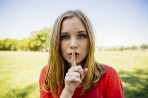 Porträt eines Mädchens im Freien, das den Finger auf den Mund legt - AIF000057