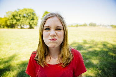 Portrait of teenage girl outdoors grimacing - AIF000060