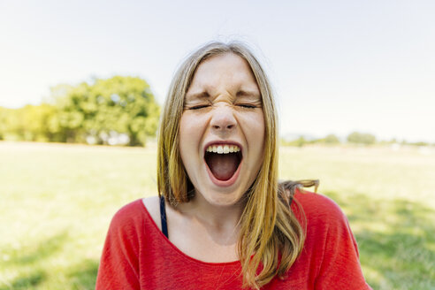 Portrait of teenage girl outdoors screaming - AIF000061