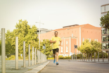 Deutschland, Stuttgart, lächelnder Mann beim Joggen in der Stadt - JUNF000418