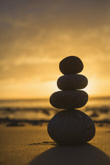 Spain, Valdovino, four stones in balance on the beach at backlight - RAEF000330