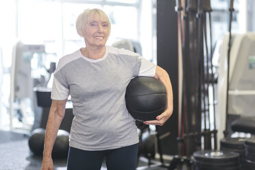 Ältere Frau im Fitnessstudio hält Medizinball - MADF000513