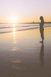 Frankreich, La Baule, Silhouette einer am Strand stehenden Frau bei Sonnenuntergang - GEMF000312