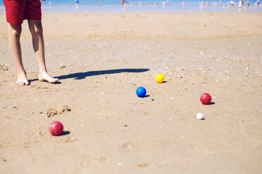 Boy standing on the beach playing boccia - GEMF000314