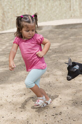 Kleines Mädchen läuft vor einer Ziege weg - ERLF000010