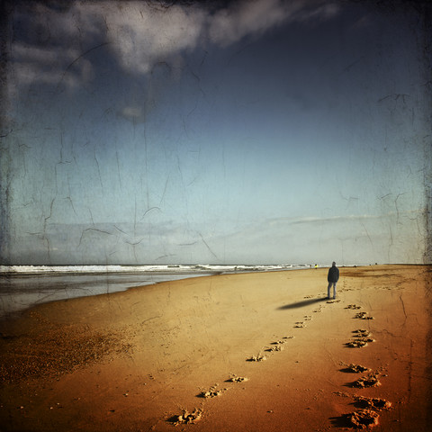 Frankreich, Contis-Plage, Mann geht am Strand spazieren und schaut auf das Meer, lizenzfreies Stockfoto