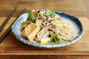 Asiatischer Nudelsalat mit Soba-Nudeln, Tofu, grünen Zwiebeln, gelben Zucchini und Koriander, garniert mit schwarzem Sesam - HAWF000827