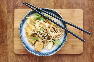 Asian noodle salad with soba noodles, tofu, green onions, yellow zucchini and coriander, garnished with black sesame seeds - HAWF000829