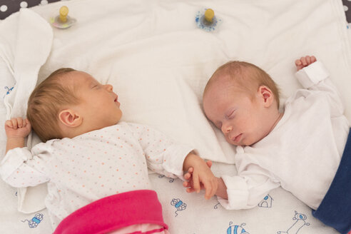 Neugeborene Zwillinge schlafen Hand in Hand - SHKF000348