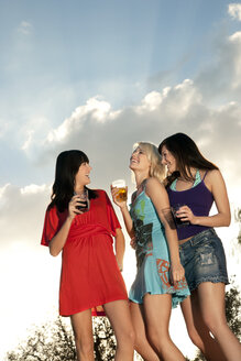 Drei glückliche junge Frauen feiern eine Party im Freien - TOYF001077