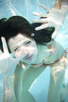 Porträt einer jungen Frau unter Wasser in einem Schwimmbad - TOYF001103